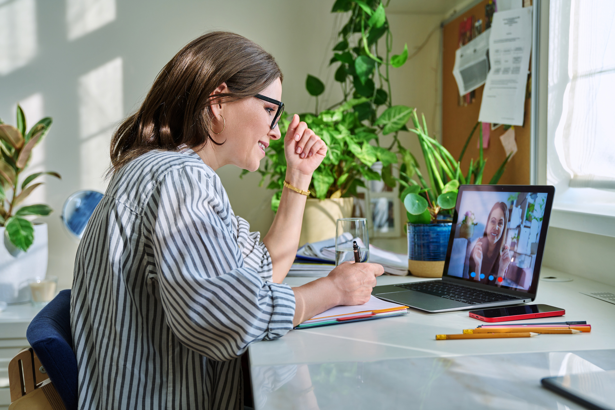 Middle aged businesswoman having video conference on laptop with young woman sitting at table at home. Remote online meeting, video call chat, business, education, work from home concept