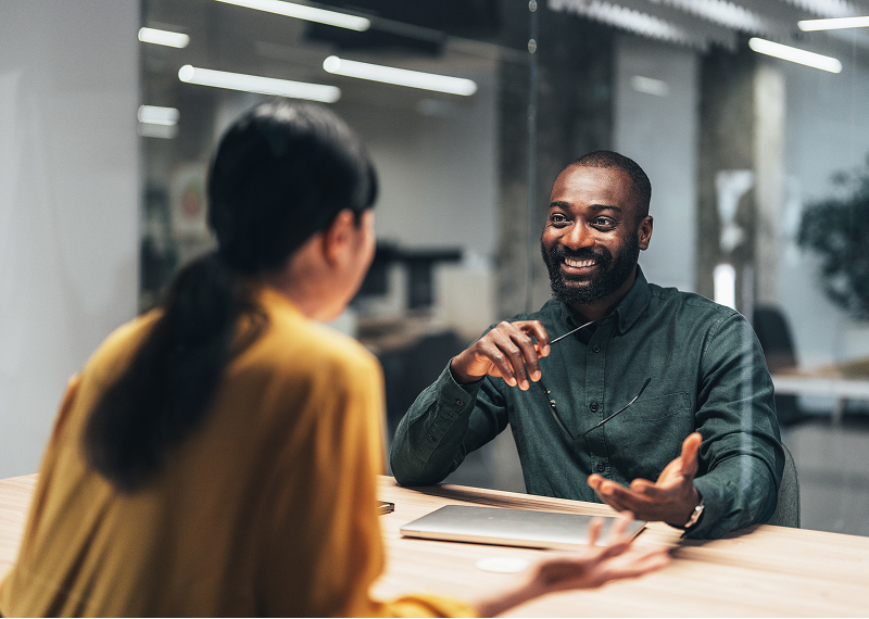 Two people having a conversation in office.